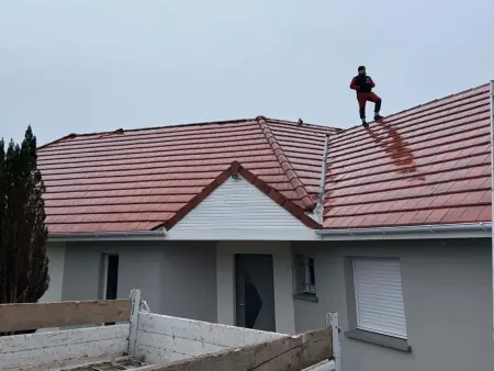 Couvreur sur une toiture en tuiles d'une maison de l'agglomération paloise