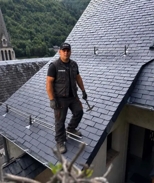 Artisan couvreur de Couverture Midi Pyrénées sur une couverture en ardoise naturelle, dans le Béarn
